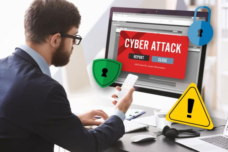 Man with smartphone and computer at table. Notification about threat of cyber attack on screens